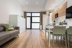 uma cozinha e sala de estar com uma mesa e um sofá em Marina Beach Apartments em Valência