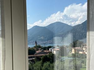a window with a view of a city and mountains at Terrazza sul lago (CIR 017085-LNI-00027) in Iseo