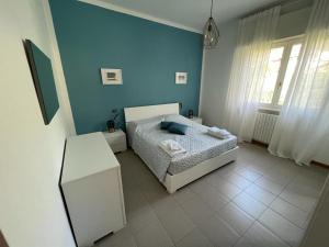 - une chambre avec un lit et un mur bleu dans l'établissement Terrazza sul lago (CIR 017085-LNI-00027), à Iseo