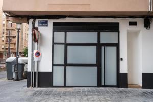 バレンシアにあるMarina Beach Apartmentsの駐車場メーター付きの建物のガラス戸