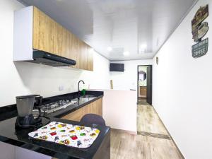 a kitchen with a stove and a counter top at Apartaestudio para estrenar La Quinta in Ibagué