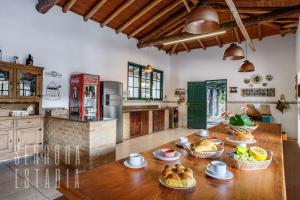 uma cozinha com uma mesa de madeira com cestos de comida em Alpen Ville Sítio com Piscina Inesquecível em São Pedro de Alcântara