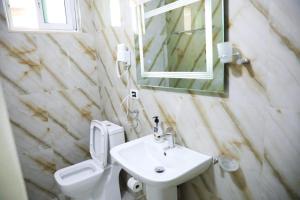 uma casa de banho com um lavatório, um WC e um espelho. em MERKAJ HOTEL BERAT em Berati