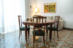 a dining room table with chairs and a couch at Dimora del Castellano in Gioia del Colle