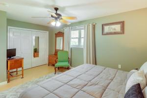 een slaapkamer met een bed en een groene stoel bij Spacious Yellville Retreat with Deck and Balcony in Yellville