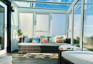 a room with a couch in front of a window at Sunset House On The Beach in Maryport