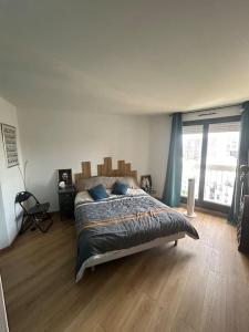 Un dormitorio con una cama grande con almohadas azules. en Superbe T2 type loft proche Paris La Défense Arena et 30 min stade de France, en Puteaux