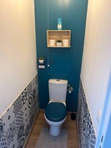 a small bathroom with a toilet with a blue wall at Superbe T2 type loft proche Paris La Défense Arena et 30 min stade de France in Puteaux
