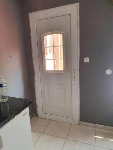 a white door in a kitchen with a window at studio tranquille in Pavillons-sous-Bois