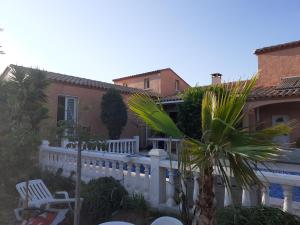 een huis met een wit hek en een zwembad bij villa avec piscine privée in Pia