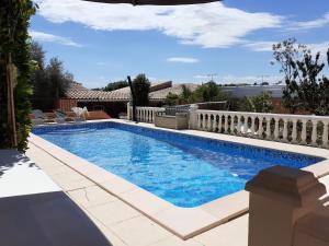 een zwembad in een achtertuin met een wit hek bij villa avec piscine privée in Pia