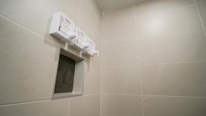 a bathroom with a shower with a thermometer on the wall at Manoir Belle Plage in Carleton sur Mer