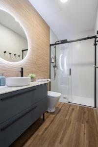 een badkamer met een wastafel, een toilet en een douche bij Marina Beach Apartments in Valencia