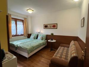 a small bedroom with a bed and a couch at Tang house 唐舍 in Budapest