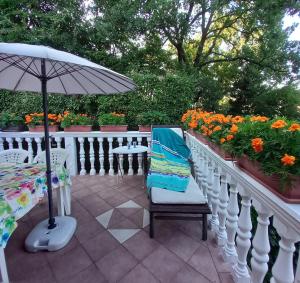 a patio with a table and an umbrella and flowers at Villa Maria in Opatija