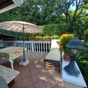 a patio with a table and an umbrella and a bench at Villa Maria in Opatija