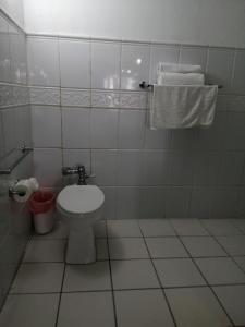 a bathroom with a toilet and towels on the wall at Freedom Shores "La Gringa" Hotel - Universally Designed in Isla Aguada