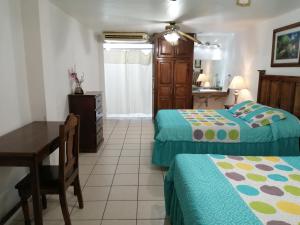 Habitación con 2 camas, escritorio y cocina. en Freedom Shores "La Gringa" Hotel - Universally Designed, en Isla Aguada