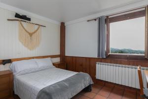a bedroom with a bed and a large window at Agroturismo Kostegi in Urnieta