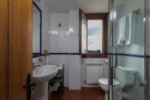 baño con lavabo y aseo y ventana en Agroturismo Kostegi en Urnieta