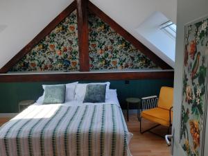 a bedroom with a bed with a floral wall at Le Pavillon du Manoir de Conjon in Crouay