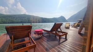 eine Holzterrasse mit zwei Stühlen auf einem Boot in der Unterkunft Lake house Perucac in Bajina Bašta
