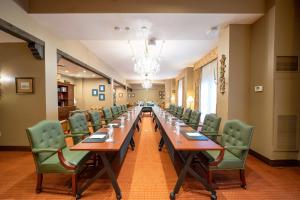 einen langen Tisch in einem Zimmer mit grünen Stühlen in der Unterkunft Hotel Granduca Houston in Houston