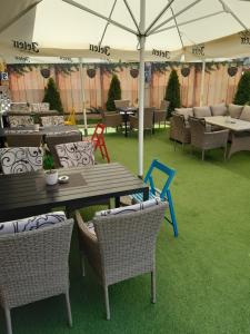 a patio with a table and chairs on grass at Hotel JET SET Pale in Pale