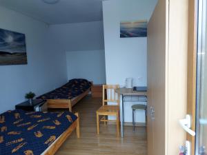 a room with two beds and a table with a desk at Big Foot by MANGO Food&Bar in Karwia