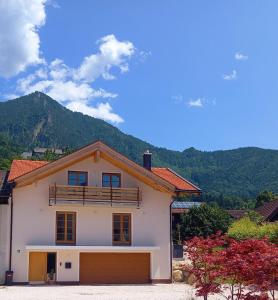 a white house with a balcony on top of it at Ferienwohnung Menter in Marquartstein