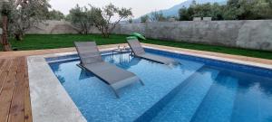 two chairs sitting next to a swimming pool at Villa Olea - Relax in nature in Fethiye