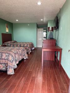 a hotel room with two beds and a desk at Roadside Inn in Floresville