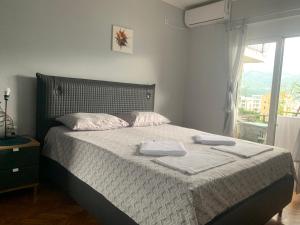 Guest House Budva في بودفا: غرفة نوم عليها سرير وفوط