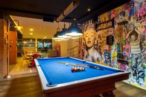 a pool table in a room with a wall covered in graffiti at GIO hotel Tama Cartagena in Cartagena de Indias