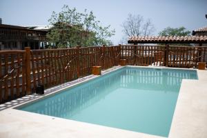 a swimming pool with a wooden fence at Resort & Villas Carević in Budva