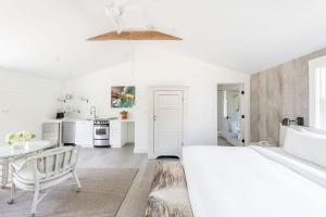 a white bedroom with a white bed and a table at White Moose Inn in Washington, Virginia