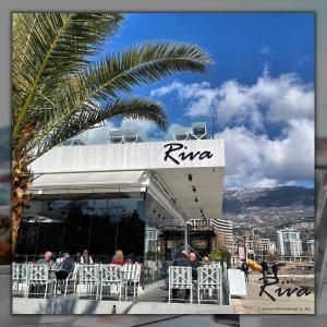 a restaurant with tables and chairs in front of a building at Hotel Riva in Budva