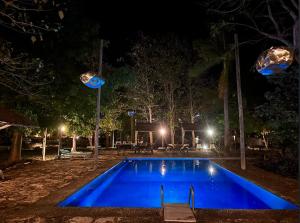 una piscina azul por la noche con luces en Villa en Hacienda noox Kankabal, en Cholul