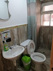 y baño con aseo y lavamanos. en Galapagos Natural Life Hostel, en Quito
