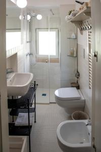 a white bathroom with a sink and a toilet at Dimora del Castellano CASA SATURNO in Gioia del Colle