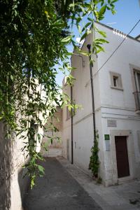 an alley with a white building with a door at Dimora del Castellano CASA SATURNO in Gioia del Colle