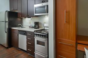 a kitchen with a stainless steel stove and a microwave at TownePlace Suites by Marriott Newnan in Newnan