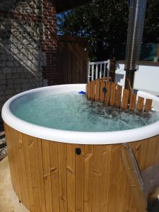 wanna z hydromasażem z wodą w drewnianym pomieszczeniu w obiekcie AU BAIN Normand : bain nordique et détente. w mieście Goderville