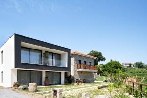ein weißes Haus mit schwarzem Dach in der Unterkunft CASA DAS FONTELAS in Castelo de Paiva