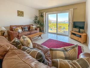 sala de estar con sofá y TV en Sealladh Apartment - Ukc6792, en Port Appin