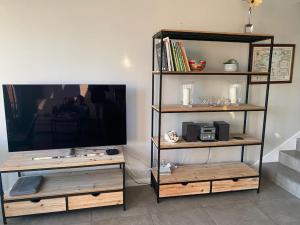 a living room with a tv and a book shelf at Deauville, Superbe F4 - Marina - double expo vue mer rare ! in Deauville