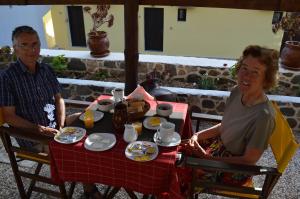 mężczyzna i kobieta siedzący przy stole w obiekcie Romantzo w mieście Mandrákion