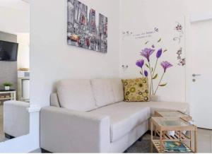uma sala de estar com um sofá branco e uma mesa em דיזנגוף סנטר חניה פרטית מרפסת שמש em Tel Aviv