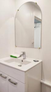 Baño blanco con lavabo y espejo en Appartement 2 Pièces à 5 Minutes des Musées, en Grasse