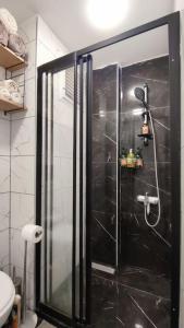 La salle de bains est pourvue d'une douche avec une porte en verre. dans l'établissement Прекрасный вид на море, à Mezitli